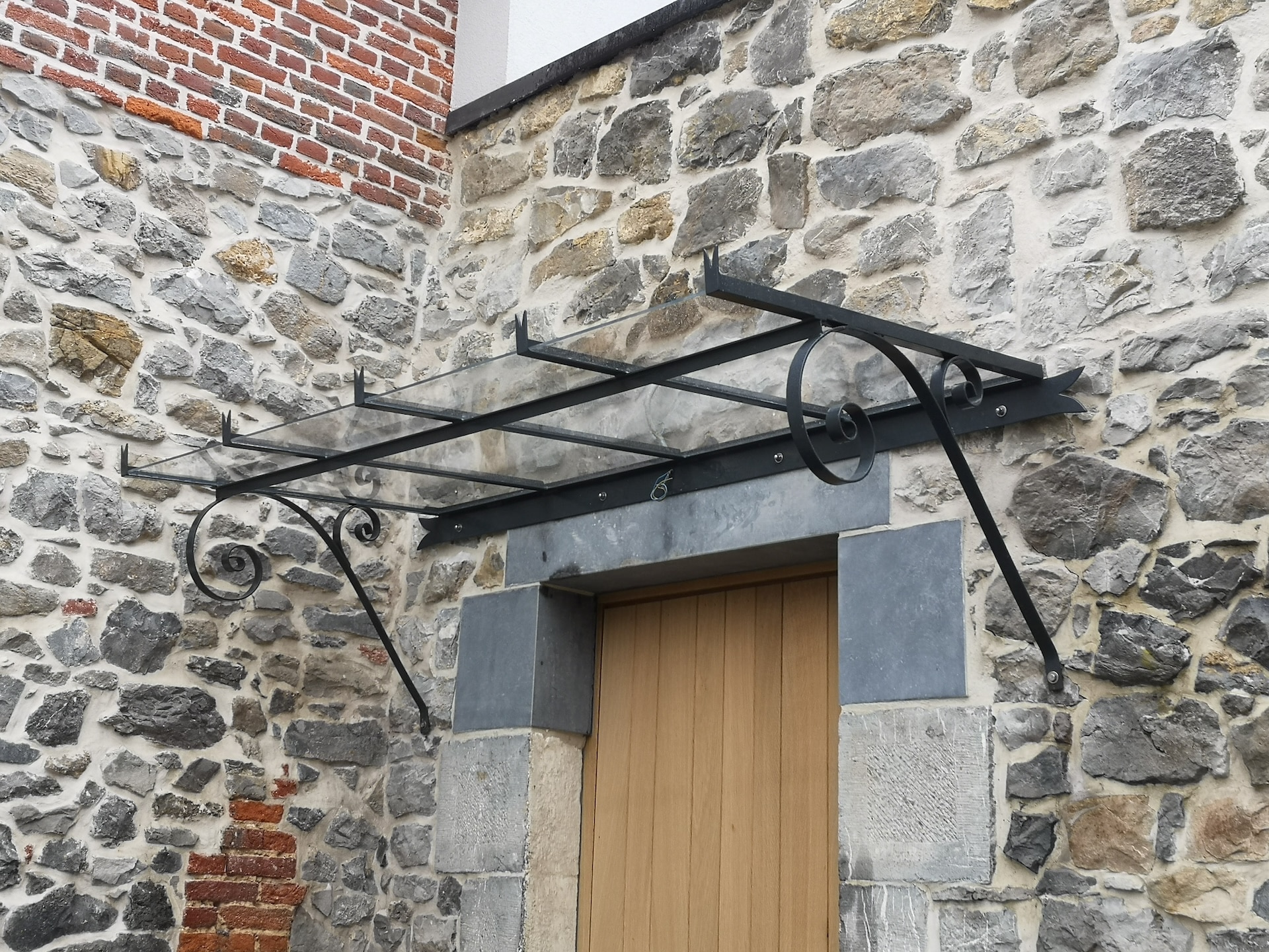 Marquise en fer forgé au-dessus d'une porte.