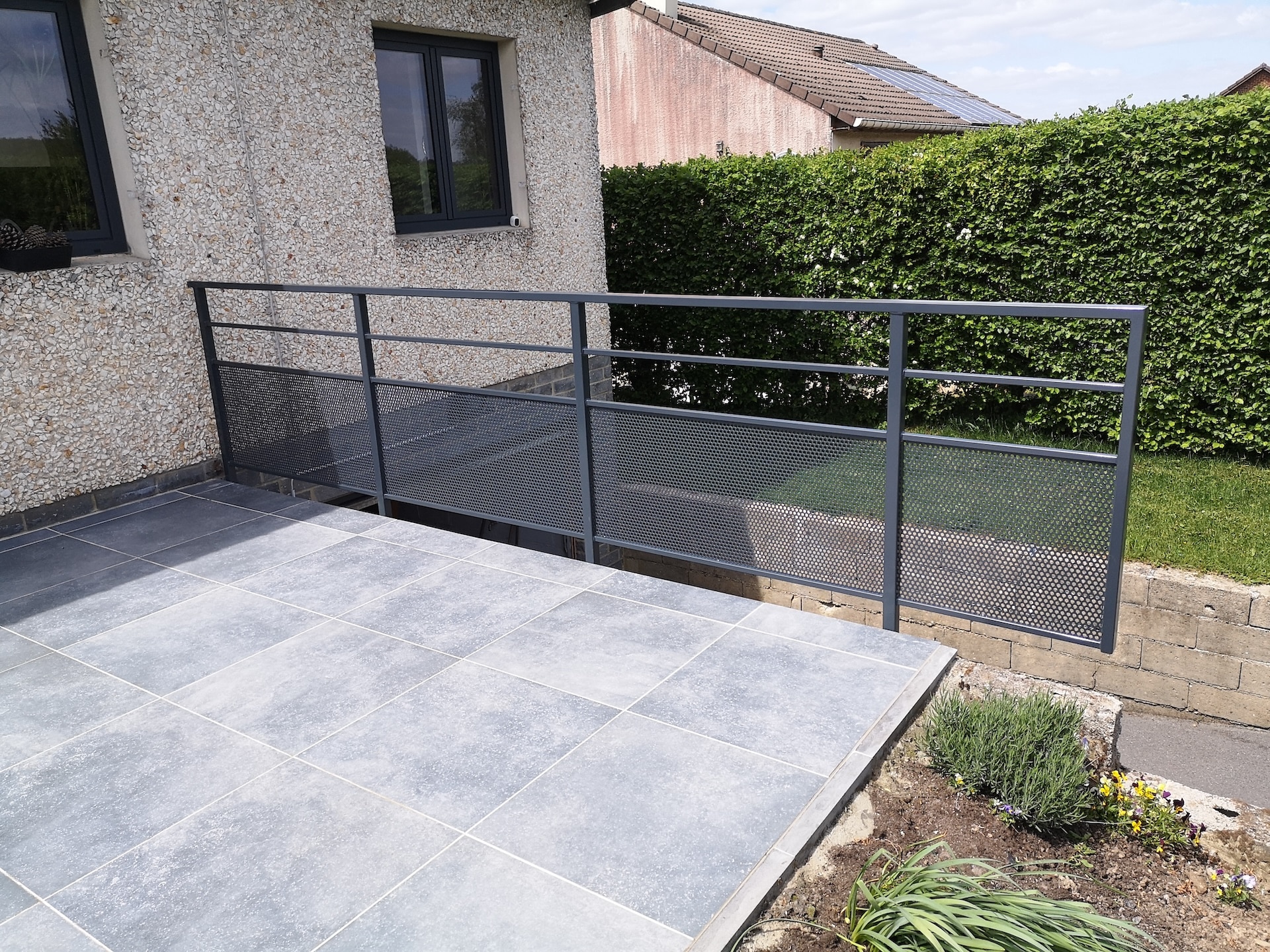 Rampe en métal sur terrasse extérieure.