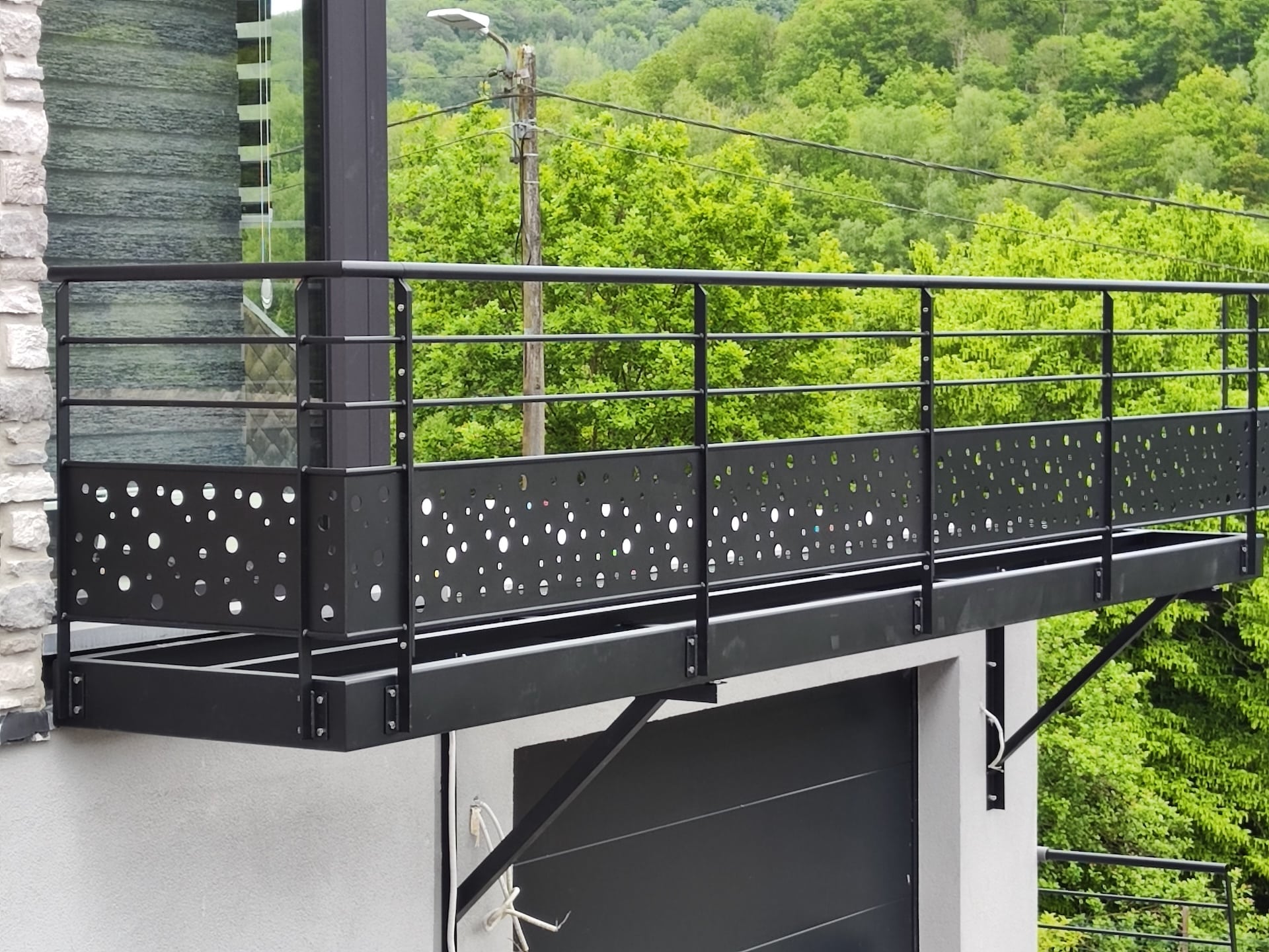 Balcon moderne avec garde-corps perforé.