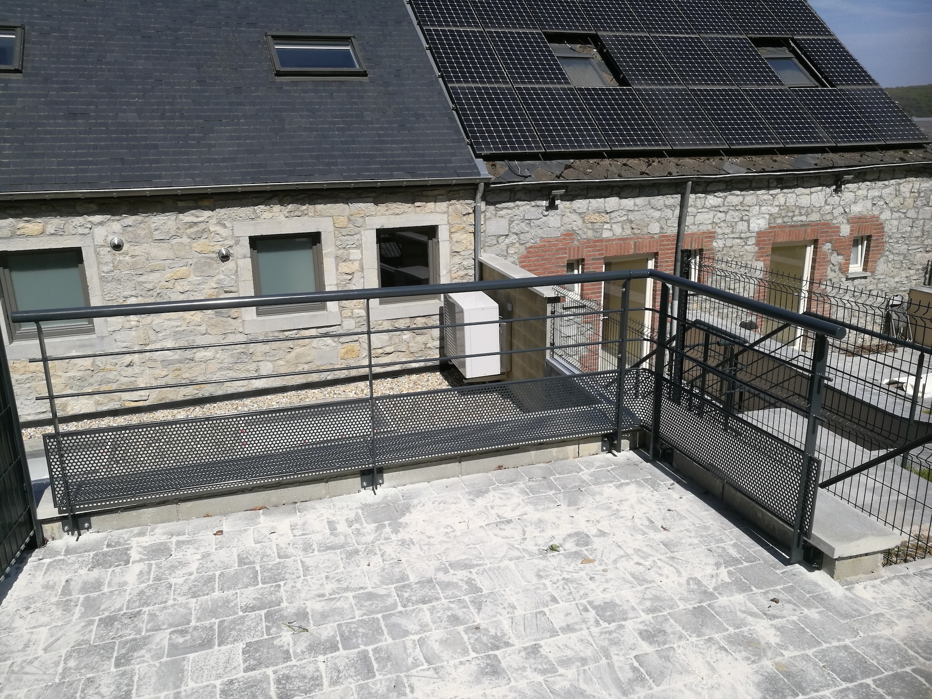 Maison en pierre avec panneaux solaires.