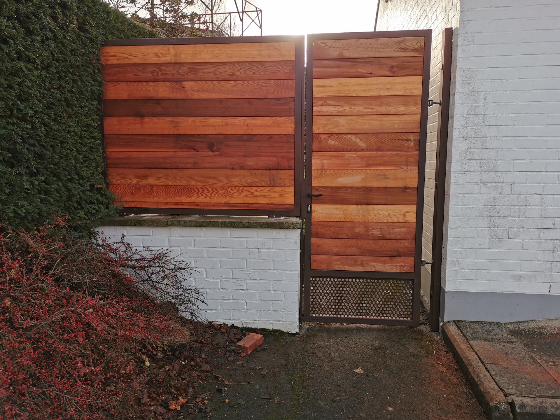 Portail en bois moderne et mur blanc.